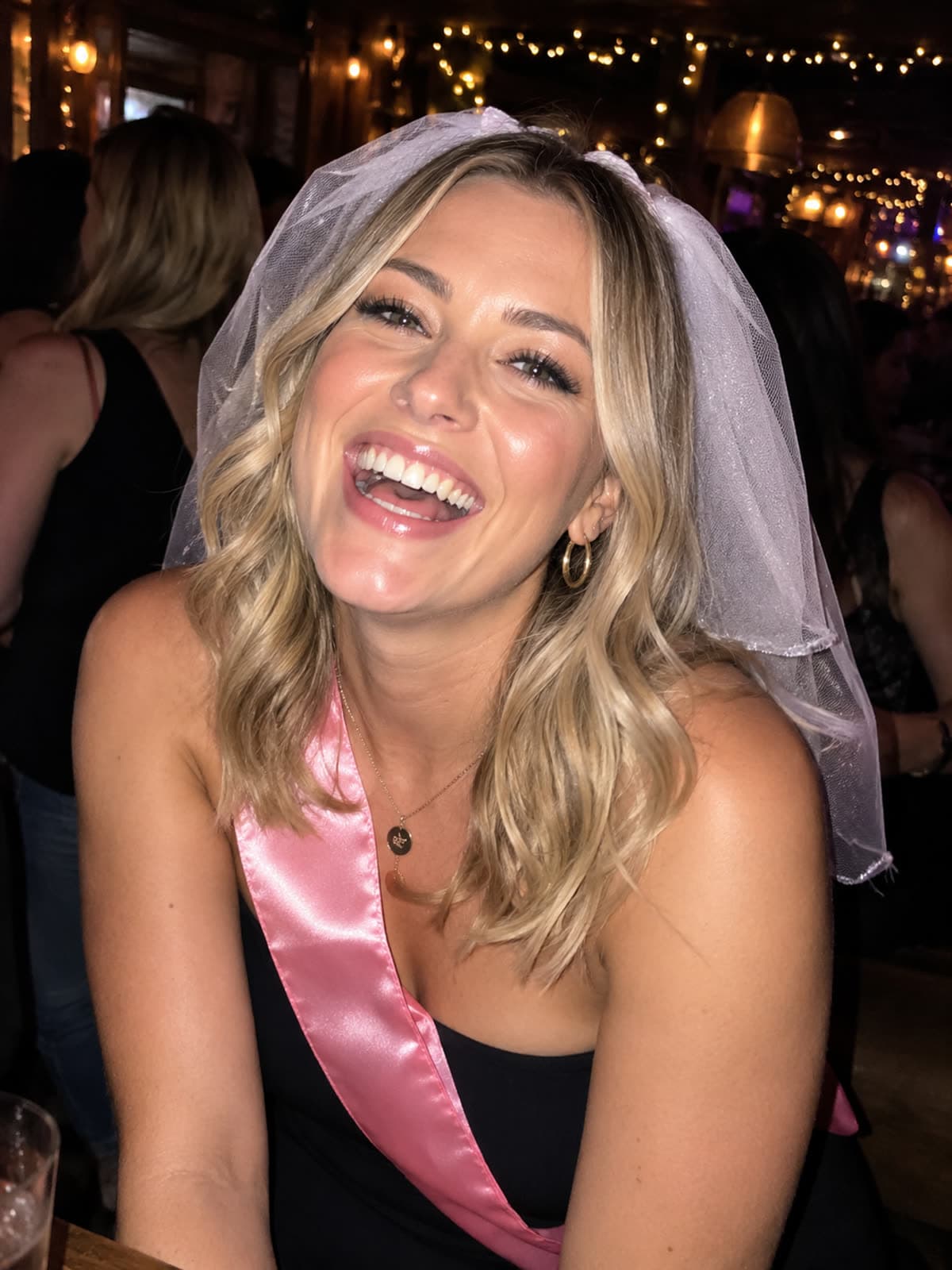 A laughing bride in a veil, mid-hen-do